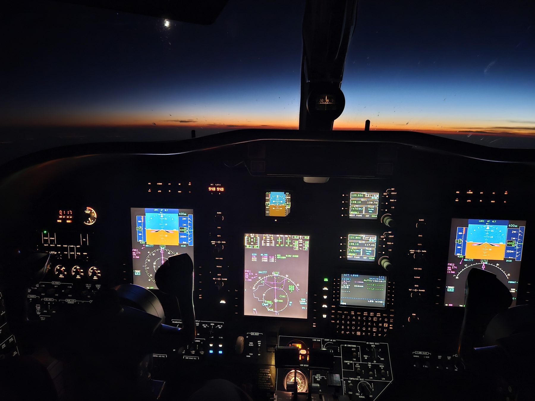 A Citation flight deck at night in cruise at FL400 with the last light of sunset on the horizon