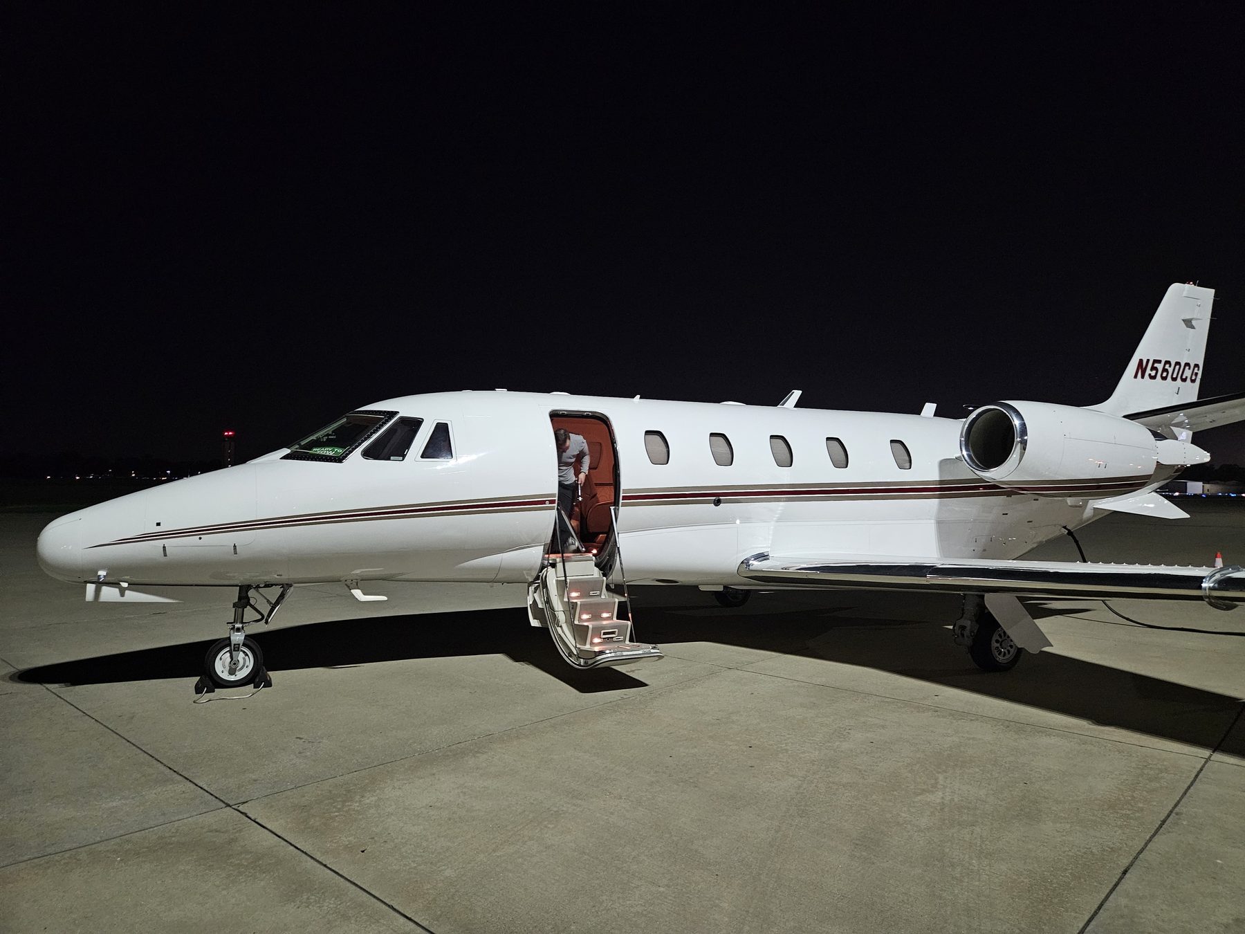 Citation Excel N560CG at night with the cabin door open and interior lights on
