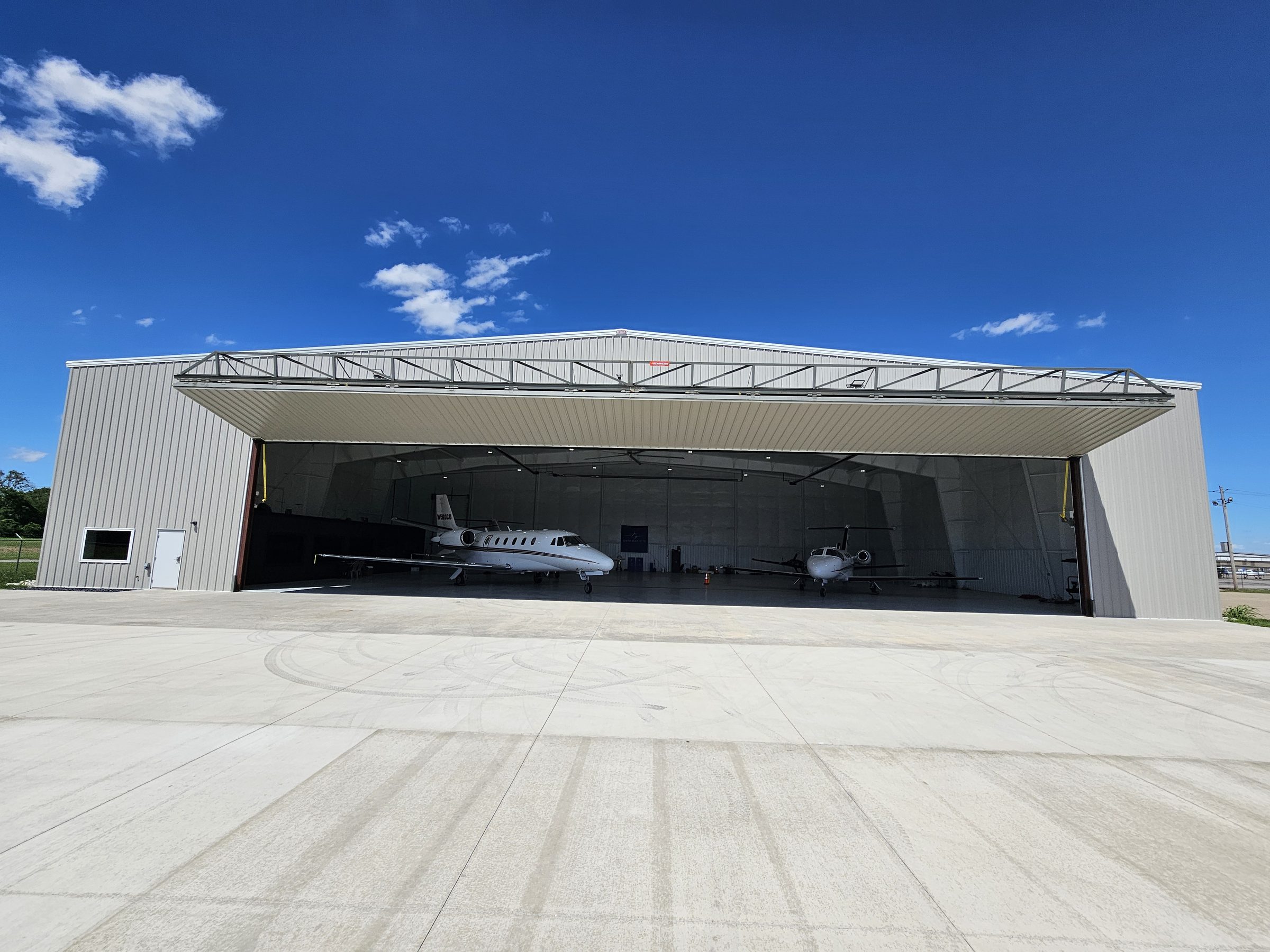 The Gateway Jets corporate hangar at St. Louis Downtown Airport with the 100-foot bi-fold door open and two Citation jets inside