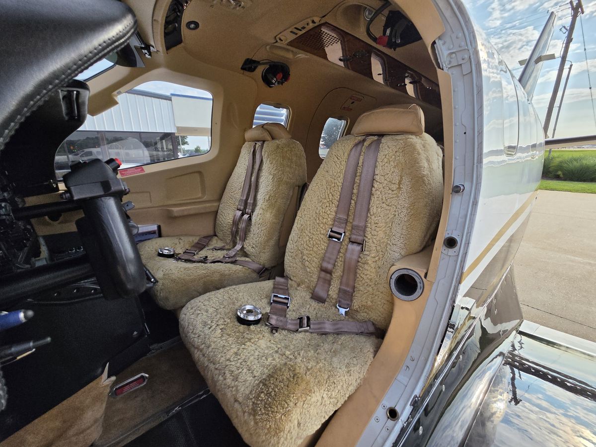 Forward cabin seats of TBM 700C2 N6272B viewed through the open pilot door