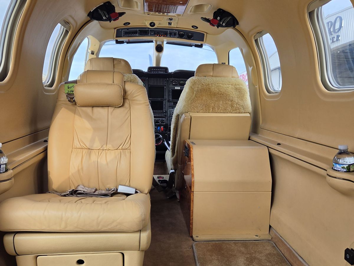 Cabin of TBM 700C2 N6272B looking forward down the aisle toward the flight deck, tan leather seating either side