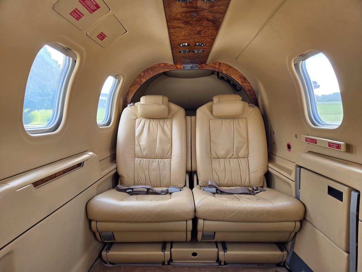 Cabin interior of TBM 700C2 N6272B looking forward at the club seating in tan leather with burl wood trim