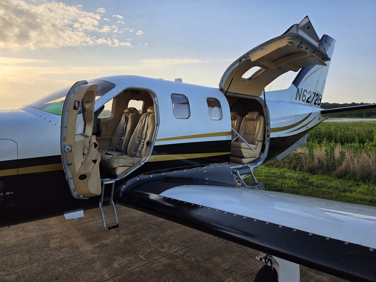 TBM 700C2 N6272B with the pilot door and cabin airstair door open at sunrise, cabin seating visible