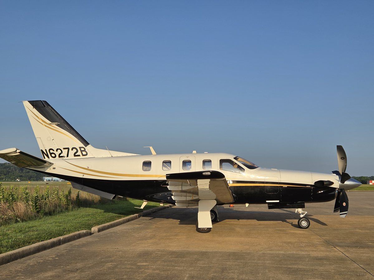 2005 TBM 700C2 N6272B in level left side profile on the ramp under clear skies