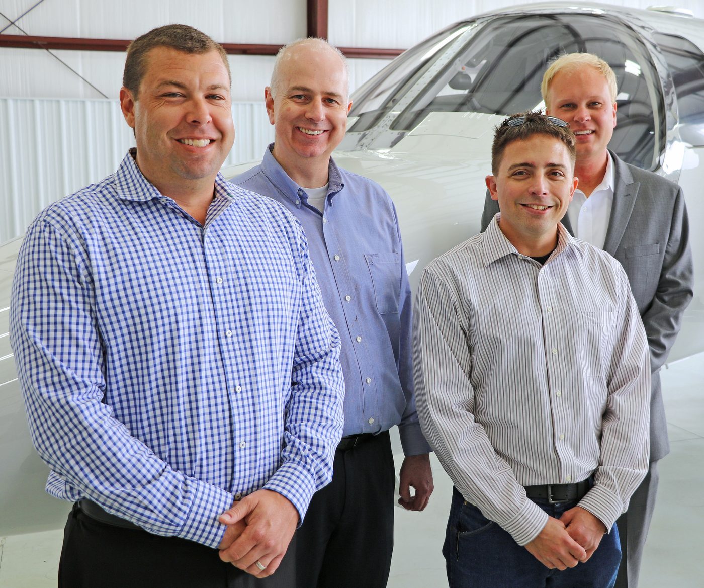 Gateway Jets team members standing beside a Citation Mustang in the hangar